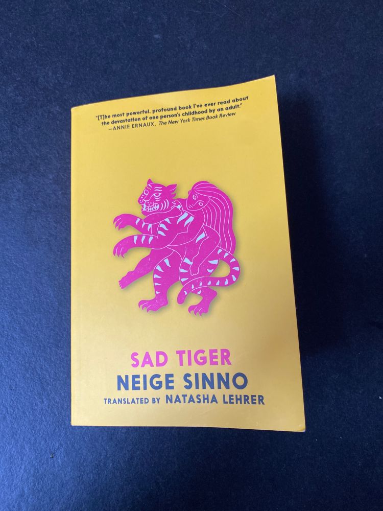 The cover of Sad Tiger by Niege Sinno. A pink drawing of a tiger and a woman on a yellow background.