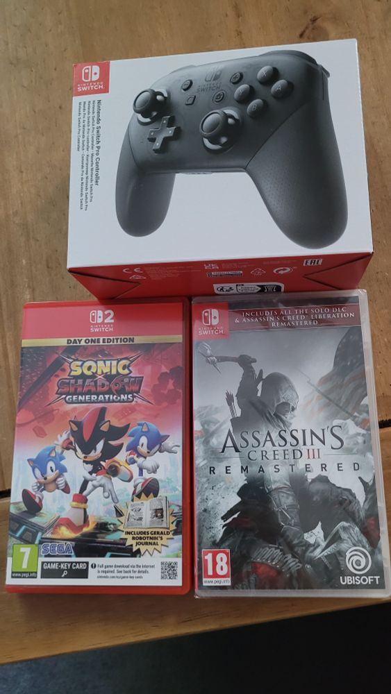 Picture of a Switch 2 pro controller and two Switch games