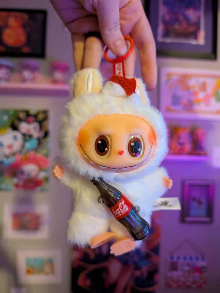 my lafufu as FUCK. coke bottle is being held to the stomach by glue and arms are stretched out wide. feet are pointed inward and loose. santa hat is in the middle of the head. eyes are wonky and soul-less.