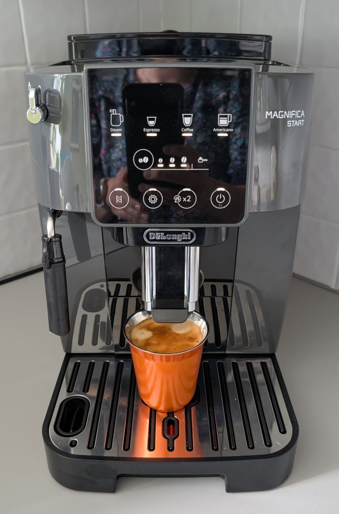 A coffee machine with an orange cup
