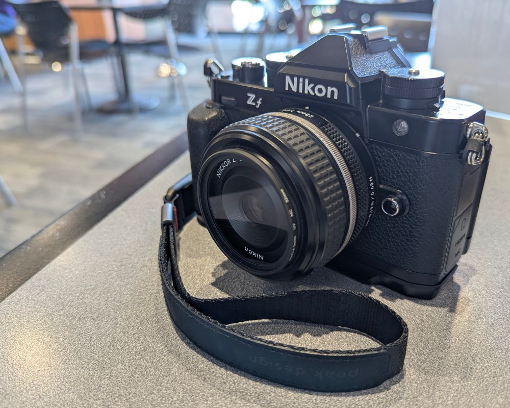 A Nikon Zf with 28mm f/2.8 SE lens attached, smallrig grip and a peak design cuff. 