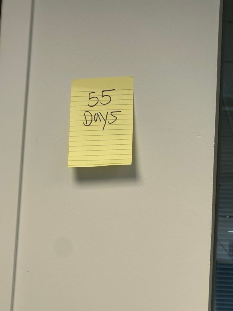 A post it note with 55 days written on it in black sharpie.