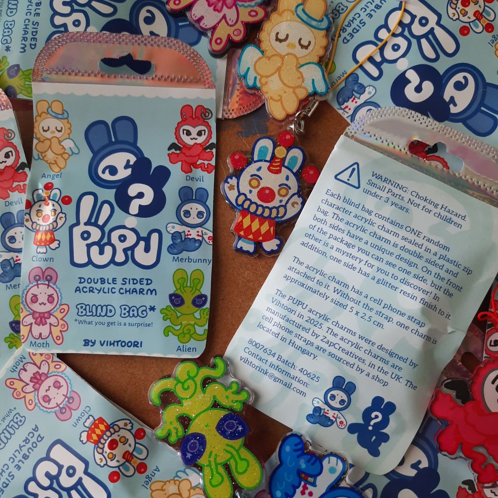 Photo focusing on the charms' packaging. On the front you can see which characters you can get and the back reads:

"WARNING: Choking hazard. Small Parts. Not for children under 3 years. 

Each blind bag contains ONE random character acrylic charm sealed in a plastic zip bag. The acrylic charm is double sided and both sides have a unique design. On the front of the package you can see one side, but the other is a mystery for you to discover! In addition one side has a glitter resin finish to it.

The acrylic charm has a cell phone strap attached to it. Without the strap one charm is approximately sized 5 × 2,5 cm.

The PUPU acrylic charms were designed by Vihtoori, in 2025. The acrylic charms are manufactured by ZapCreatives, in the UK. The cell phone straps are sourced by a shop located in Hungary.

8008634 Batch: 40625
Contact information: vihtoorink@gmail.com."