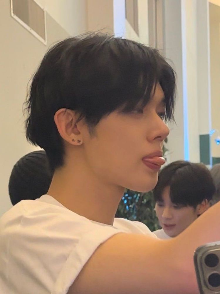 YJ at a signing concentrating with his tongue sticking out 