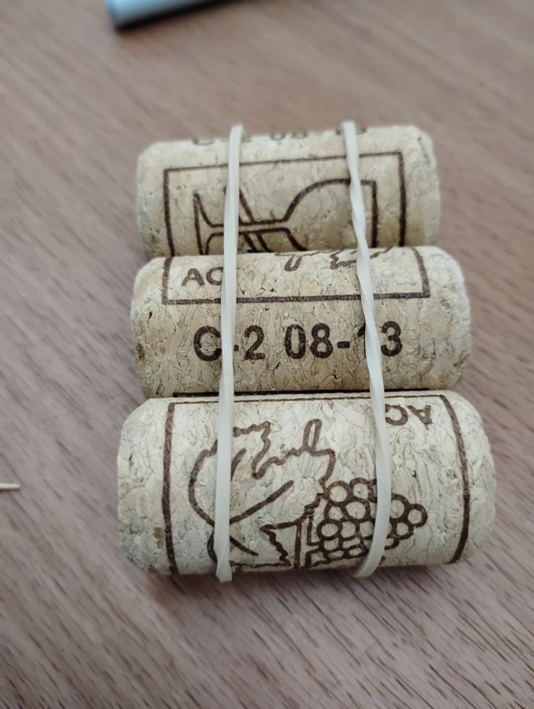 Step 1: Use two rubber bands to bind three corks together. They should look similar to a raft. 