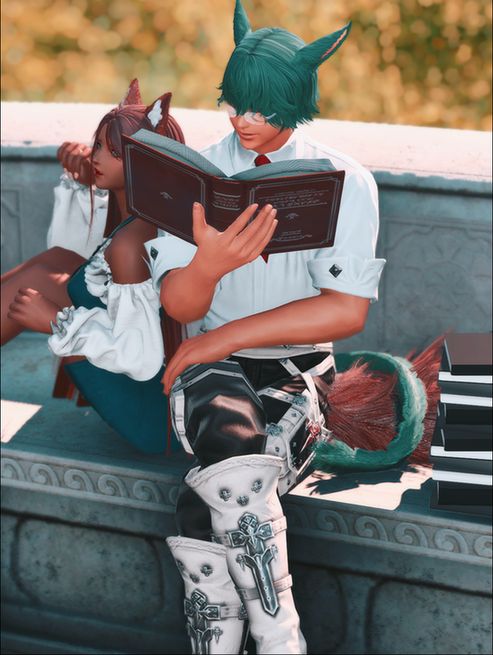 Peaches and Koana sitting outside, Koana reading a book with a stack beside him.