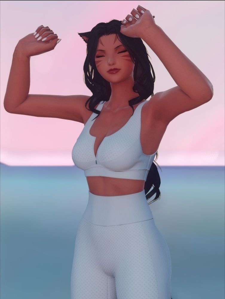 Annette in yoga pants and a sports bra, stretching overhead 