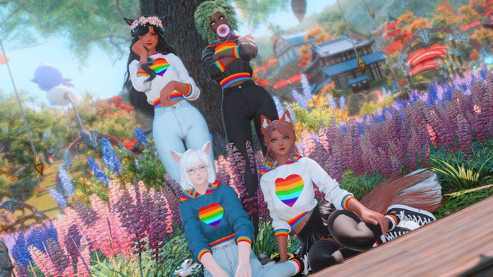 Annette, kiwi, PJ, and peaches in their pride gear seated in the lavender beds housing district