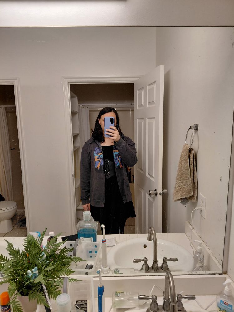 Me in a black dress, black corset and an open grey band hoodie 