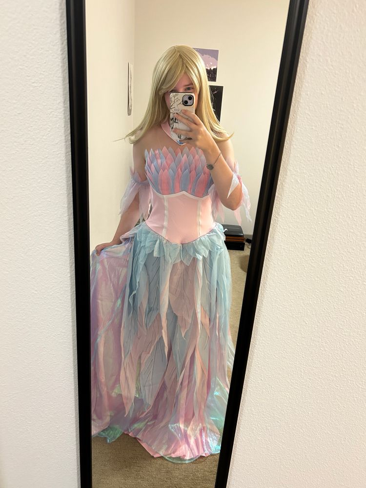 Mirror selfie of a woman wearing Barbie’s Swan Lake outfit with a blonde wig. 