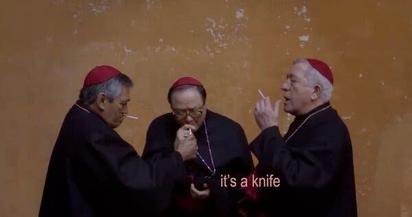 tres cardeais vestidos de preto e um chapeuzinho vermelho fumando em frente a uma parede amarela