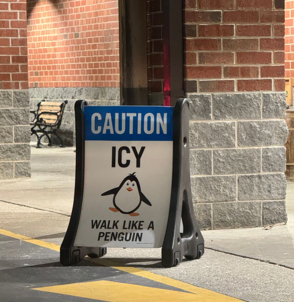 Sign with a drawing of a penguin and the caption "CAUTION: ICY -- walk like a penguin"