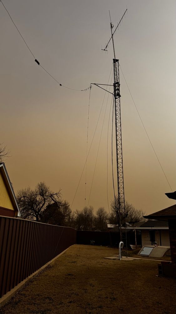 Ham radio tower with brown sky due to dust blowing into the air.