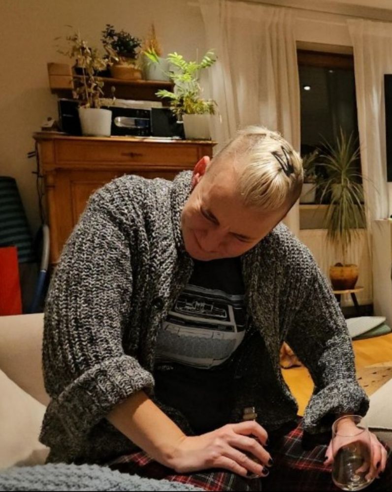 Kristen holds a shooter of Malört and looks like she's about to throw up in someone's living room 