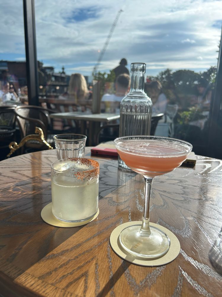 Two cocktail glasses on a table at a roof top bar in Edinburgh 