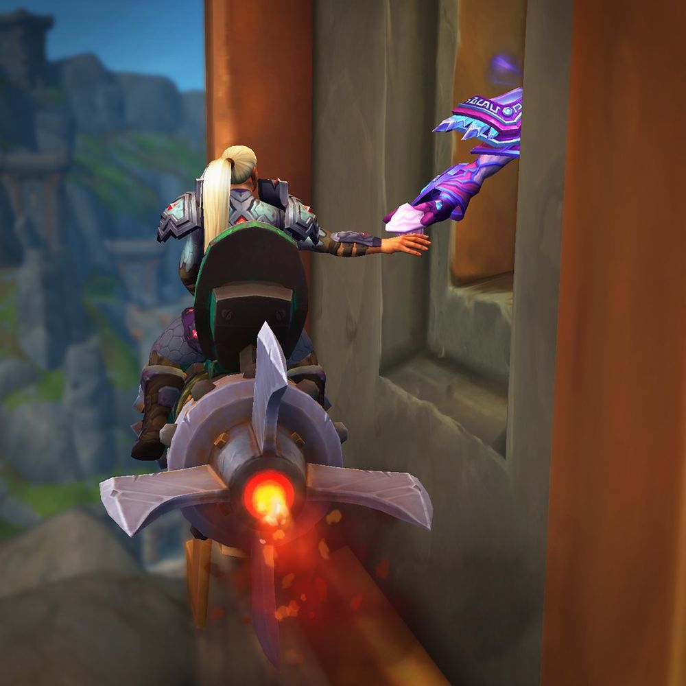 An image of a Kul Tiran player character riding a rocket mount up to what appears to be a drive-thru window and extending her hand out to receive a pink conjured treat being handed off from an unseen mage in a purple and pink robe. The square-shaped building is carved from a stone wall of an Earthen building, with a view of the mountains of the Isle of Dorn filling the background.