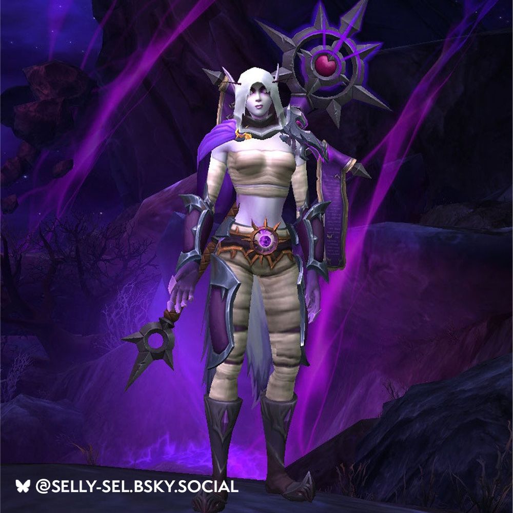 In the center of the screen stands a Void Elf woman wearing purple and white clothing. She stands amidst a dark purple background, surrounded by swirling purple energies. Her chest and legs are covered in white, wrap-like material, matching her cloth hood that partially covers her face. Upon her arms are dark purple armored gauntlets, similar to her boots. She wears a royal purple cloth cloak. On her back is a large staff, the head of which is spiked with banners draping down the staff. 