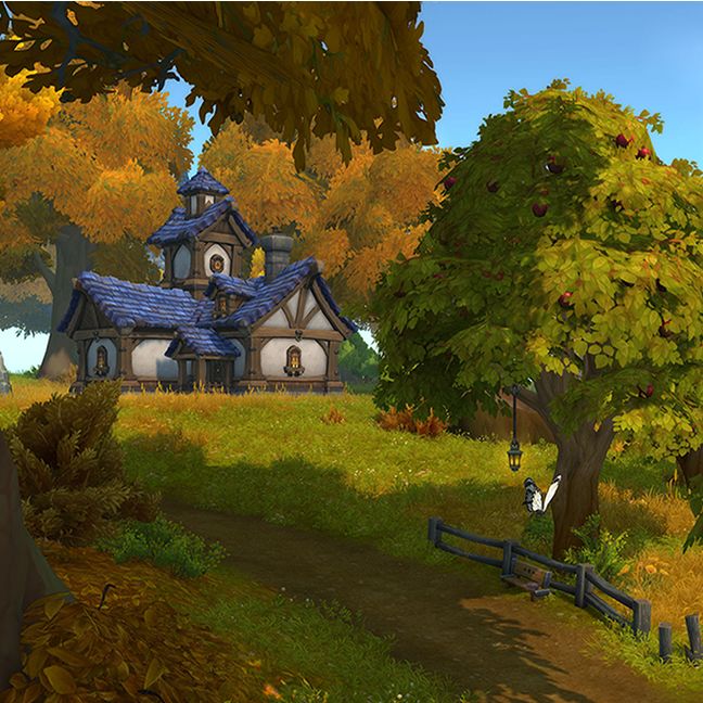 In the center of the image you see a tall apple tree, the leaves are green with their edges turning brown. There is a wooden fence and bench below the tree. Many patches of tall grass, and flowers are all over the ground. There are several other trees all around, one to the right and many others in the distance. The ground around the trees are covered in brown leaves, showing signs of the season of autumn. In the distance near the left side of the image you can see a large house. The walls are white, with traces of wooden planks along the sides giving it a rustic look. The house's rooftop is covered with large blue shingles that appear to be made out of a strong material such as stone. There is a sign of wildlife with a small butterfly near the center of the image, and a little rabbit in the lower right corner.
