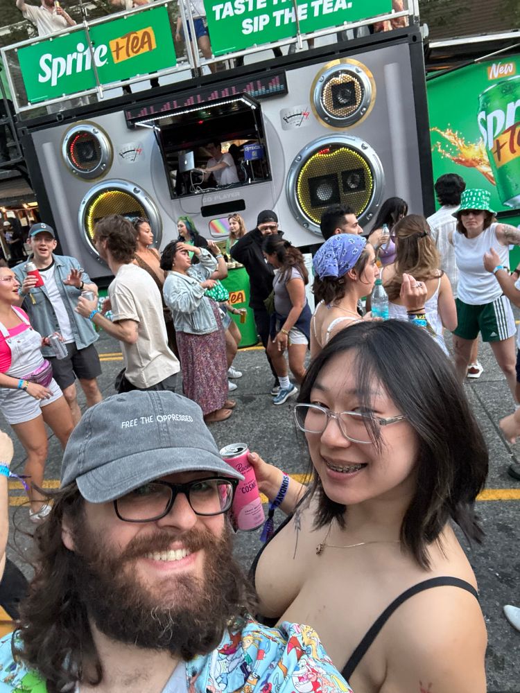 Me and my partner with a crowd dancing in front of a Sprite promotional stand featuring a DJ playing out the window.