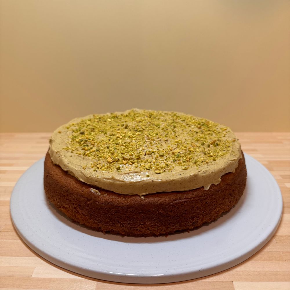 A cake with greenish icing and pistachios 