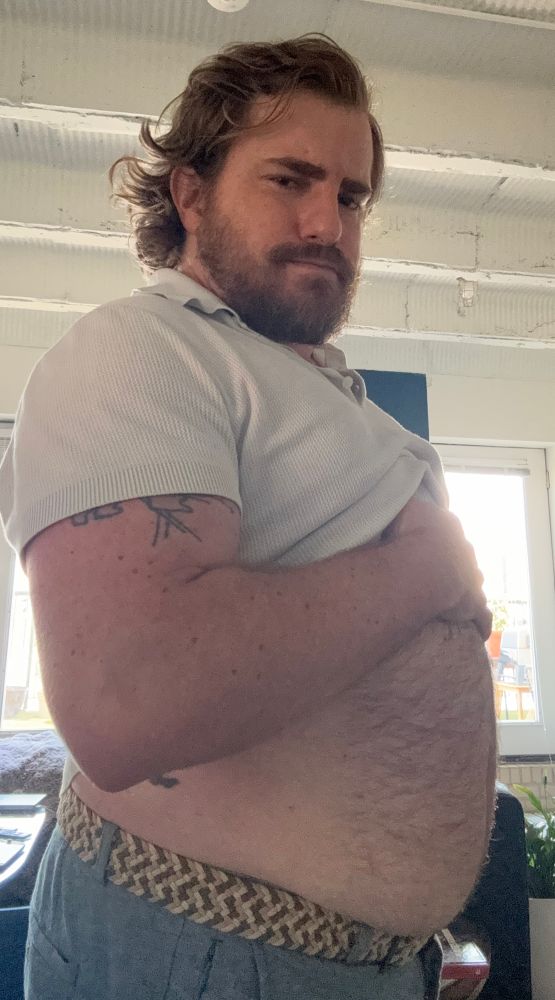 Hairy man in white polo shirt exposing belly 