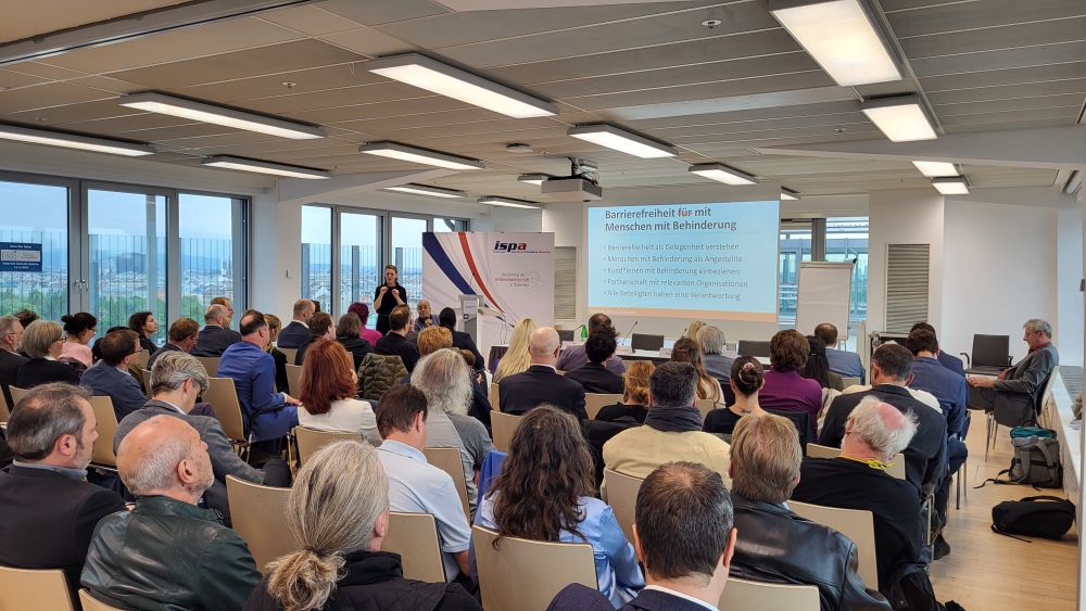 Der Saal der "Sky Lounge" der Universität Wien von hinten: Beinahe alle Plätze sind besetzt, vorne läuft die Präsentation. 