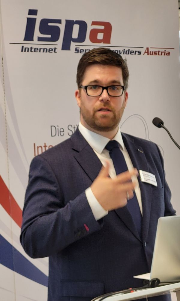 Stefan Ebenberger steht am Rednerpult vor einem Mikrofon, dahinter ein ISPA-Roll-up.