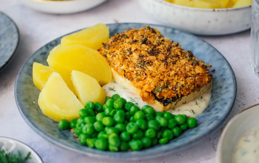 Picture of a Tofu à la Bordelaise platted with steamed potatoe, green peas and a white sauce.