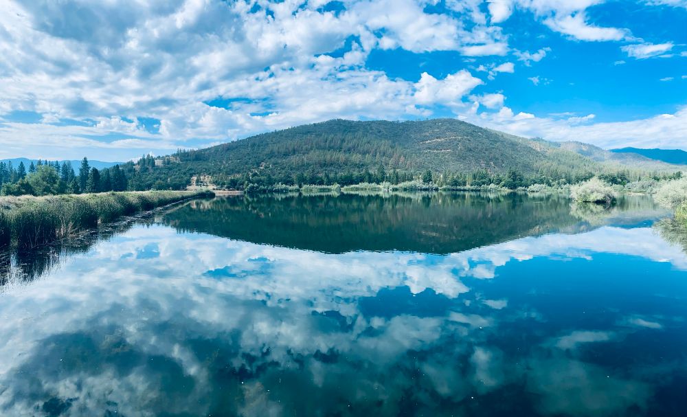 Photo of a resevoir in N. California. Water, sky and mountain creates a mirror effect. 