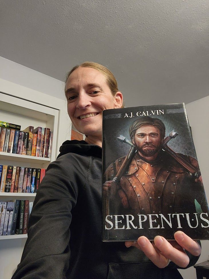 AJ Calvin holding a copy of Serpentus