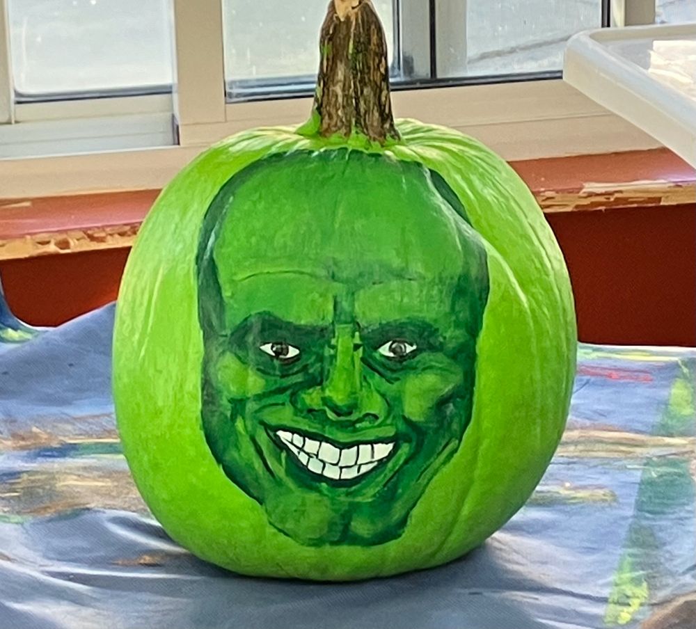 A pumpkin with a face painted on it.  The face looks vaguely like Jim Carrey in the Mask.