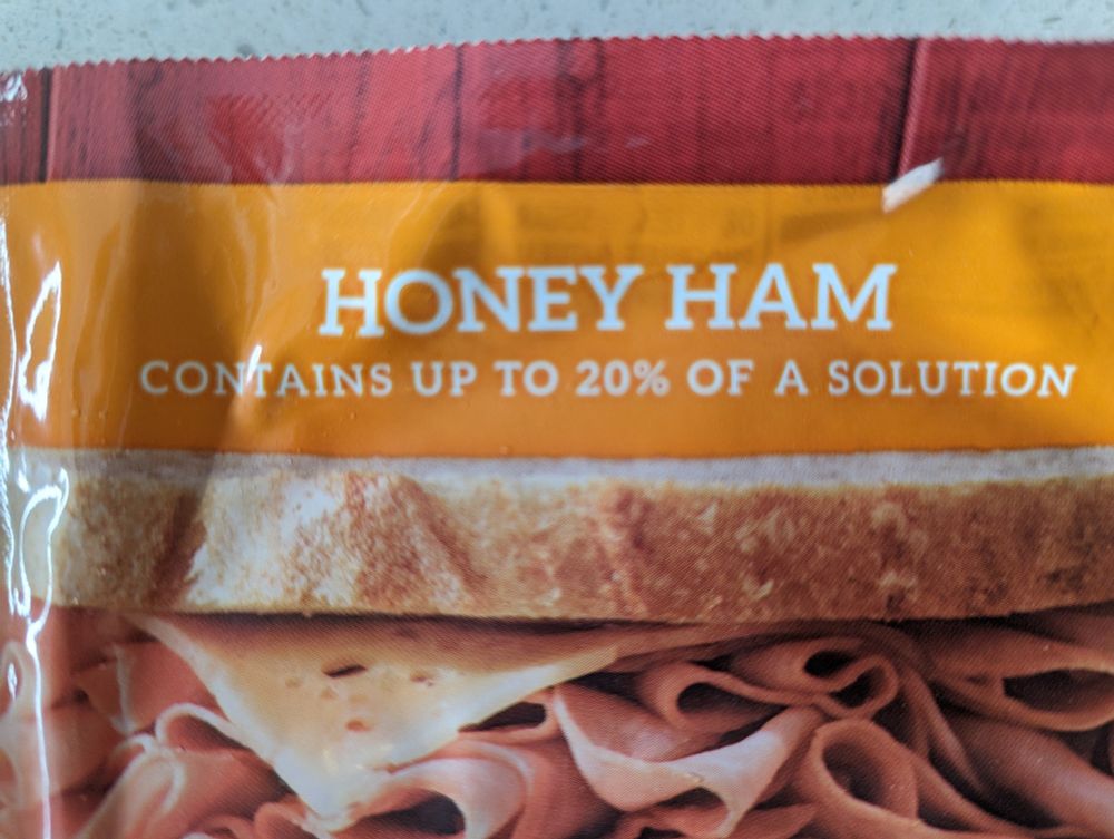 A package of honey ham that says contains up to 20% of a solution