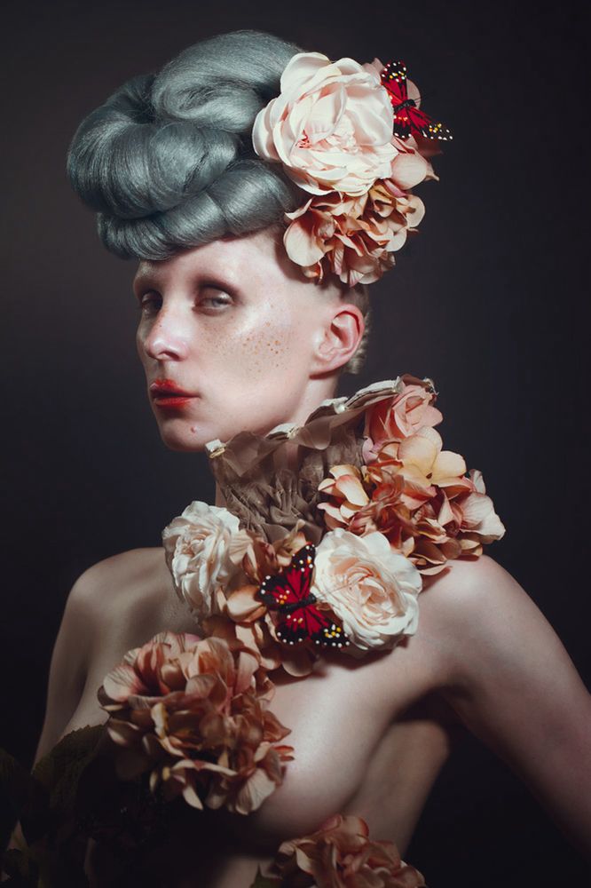 Beautiful woman in a powder gray wig and a custom neck corset made with fake flowers and butterflies