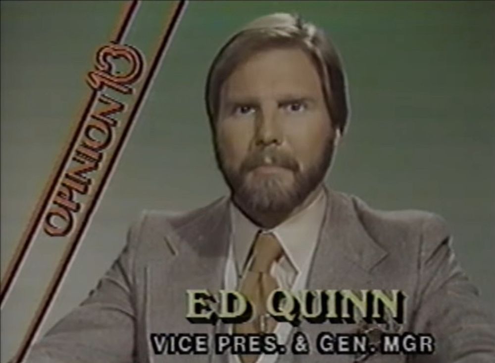 A bearded man in a suit and tie in a tv studio. 

Words on screen: 

OPINION 13
ED QUINN
VICE PRES. & GEN-MGR