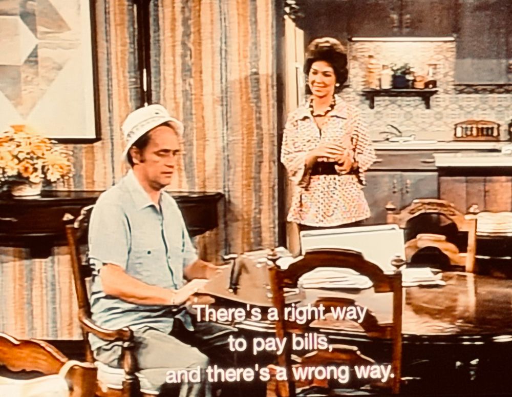 Bob Newhart and Suzanne Pleshette in a scene from The Bob Newhart Show. He is wearing his bills-playing outfit 

Caption reads:

There's a right way to pay bills;
and there's a wrong way.
