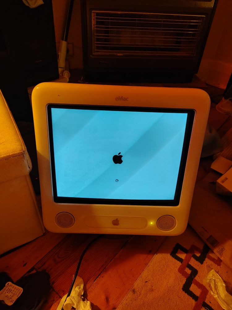 An apple emac with its screen turning on