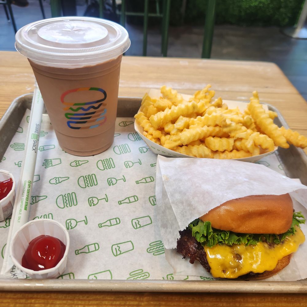 A Shake Shack burger with fries and a chocolate milkshake. 