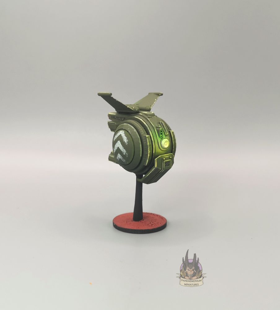 Drone - it's spherical with stablising fins at the top, in a drab green with grey chevron patterns on the side panels - front left view