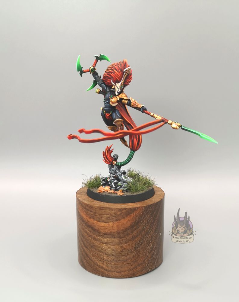 Jain Zar, Phoenix Lord of the Howling Banshees, in black armour with gold detailing and a bone mask, wielding green-bladed weapons