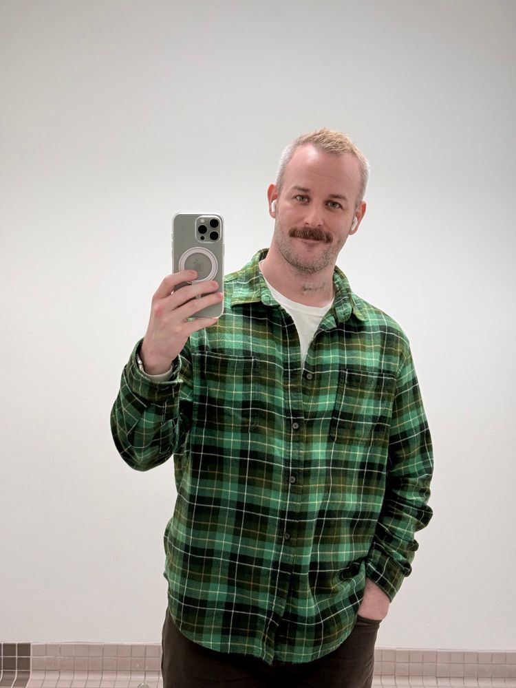 Mirror selfie wearing a green flannel 