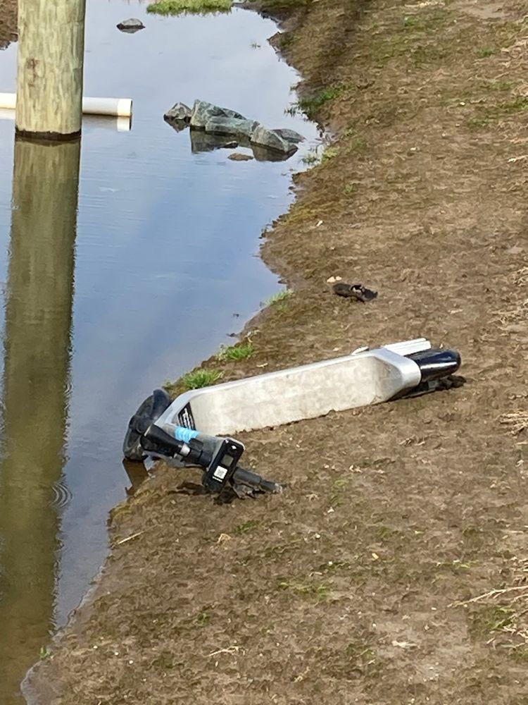 An electric scooter deserted in a culvert pipe. 