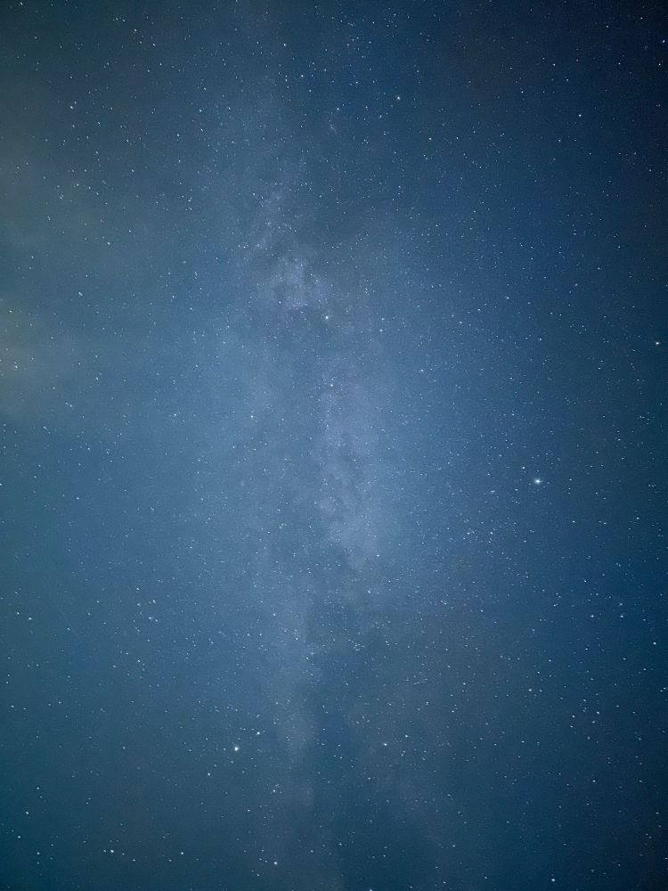 A picture of a blue hued night sky showing the Milky Way and about a trillion tiny stars 