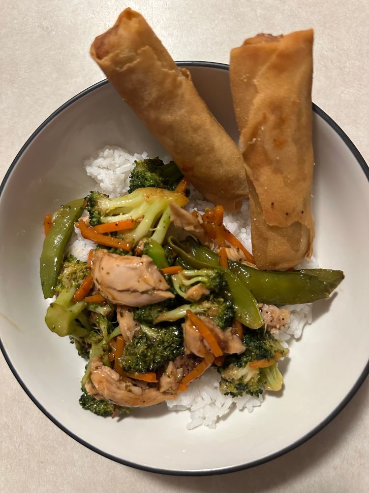 Picture of chicken stir fry with rice and two spring rolls
