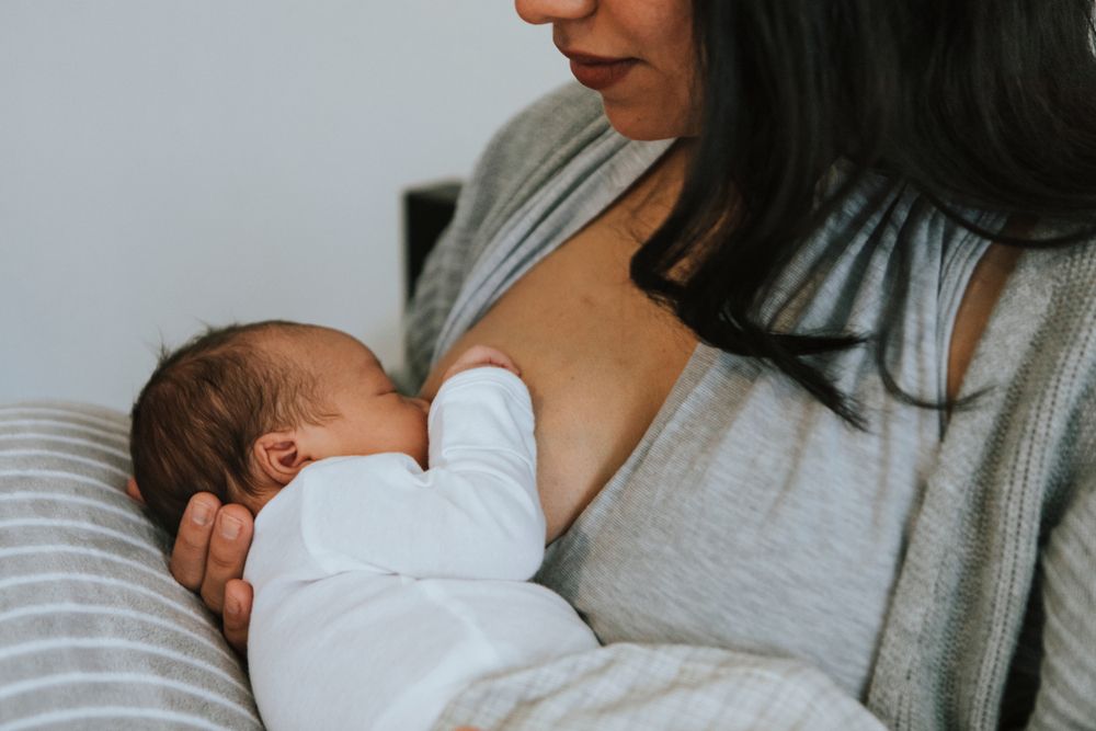 Mother breastfeeding baby. Stock photo. 