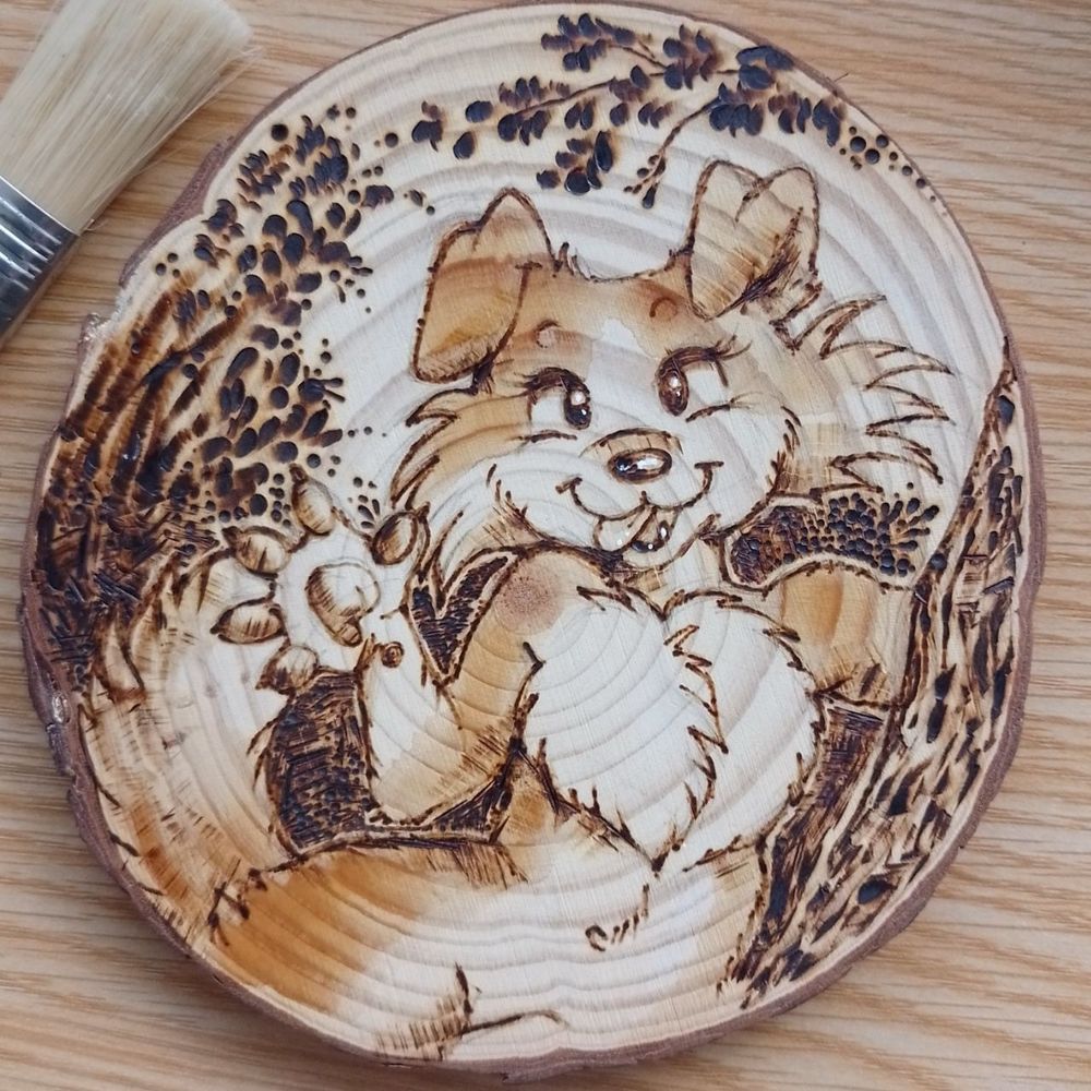 Phyrography on wood, an anthropomorphic female dog waving her paw at us