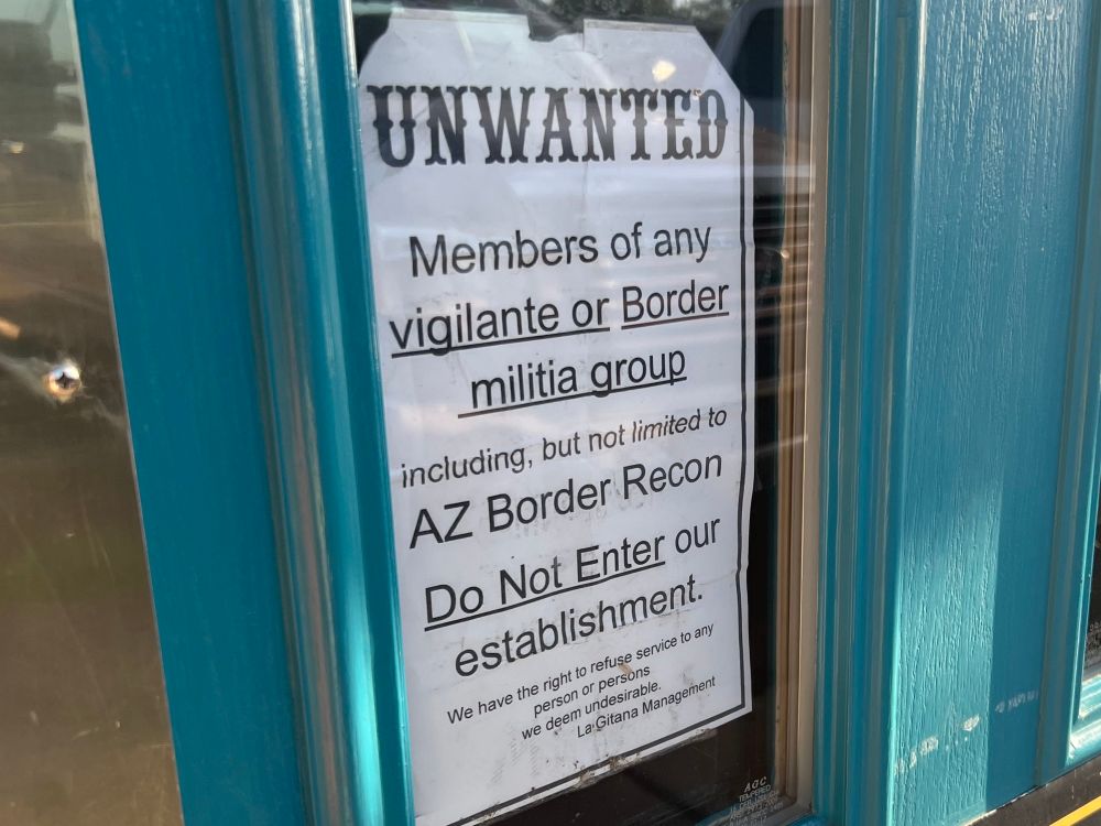 A blue door to a bar 

A sign reads 

UNWANTED
Members of any Vigilante or Border militia group including, but not limited to AZ Border Recon

Do Not Enter our establishment.
We have the right to refuse service to any person or persons we deem undesirable.
