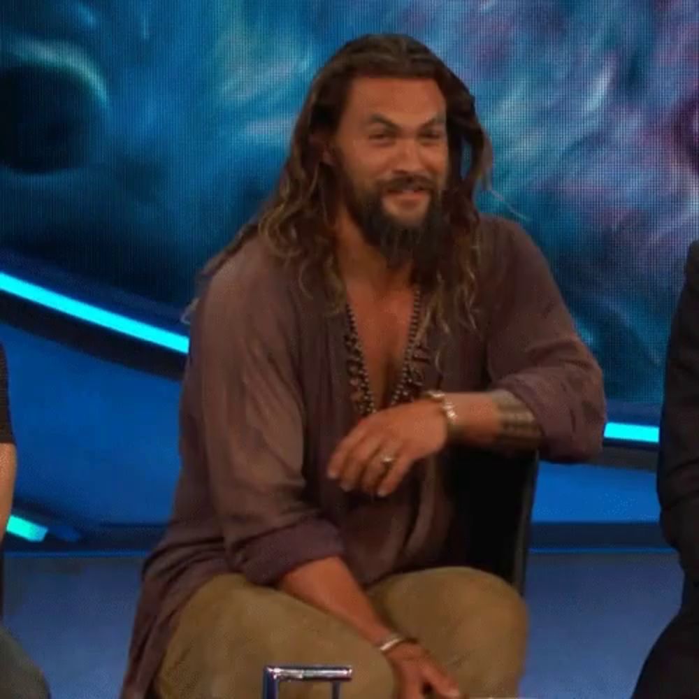 a man with long hair and a beard sitting in a chair