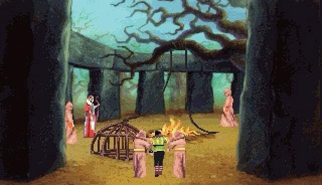 A screenshot of King’s Quest VI: Heir Today, Gone Tomorrow, showing Alexander the protagonist captured by a group of brown robe-wearing druids who are taking him to a bonfire surrounded by Stonehenge-esque rocks.