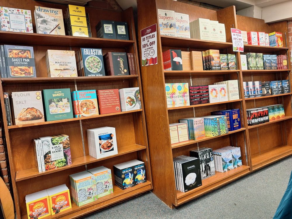 A series of bookshelves containing multiple copies of selected books. 