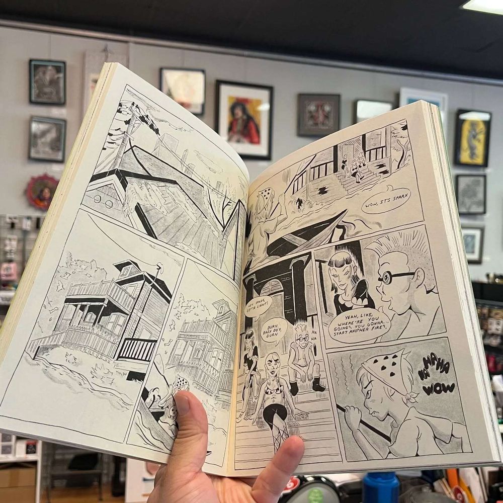 Hand holding open two (SFW) pages from "Syncing."